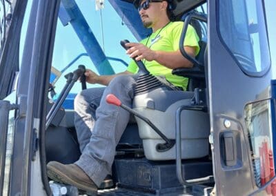 Crane operator in practical exam managing controls in crane cab