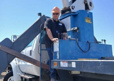 Crane operator in practical exam managing controls outside of cab on boomtruck